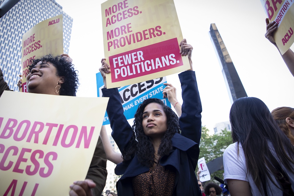 People holding signs at a rally for abortion access for all