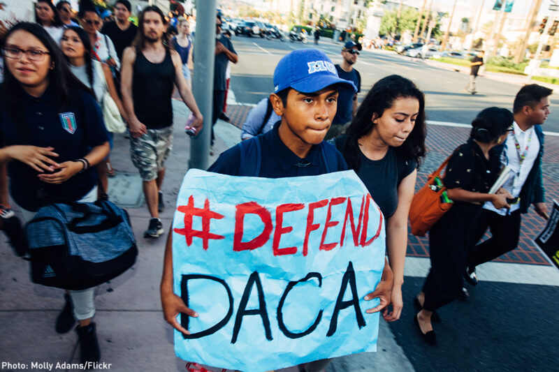 Boy holding "#Defend DACA" sign