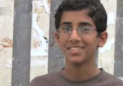 Abdulrahman Al-Aulaqi, a teenage boy with combed hair wearing glasses, smiling
