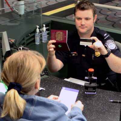 CBP officer at customs comparing IDs with woman's real face