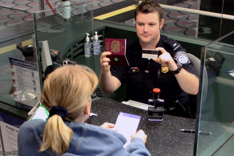 CBP officer at customs comparing IDs with woman's real face