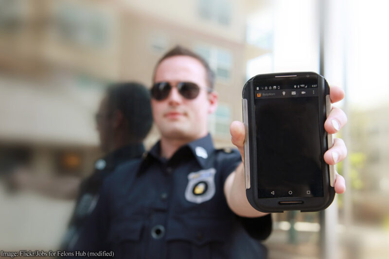Police officer holding cell phone