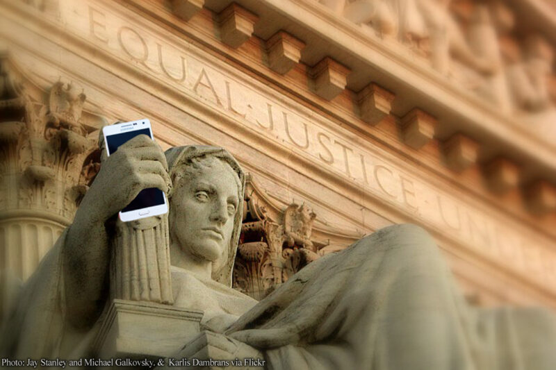 Justice figure statue holding cell phone