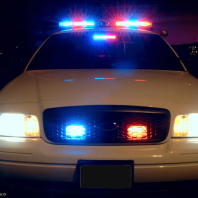 Front of police car with lights at night