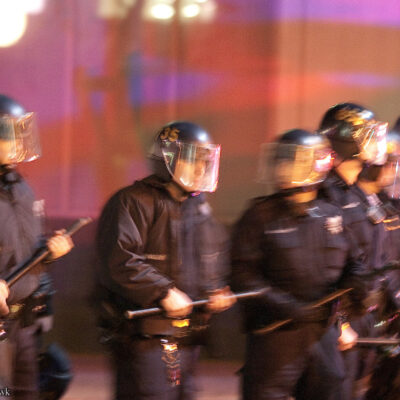 Police in riot helmets holding batons