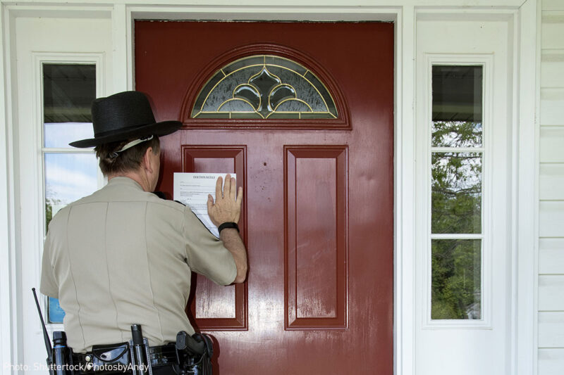 Law enforcement officer posting an eviction notice