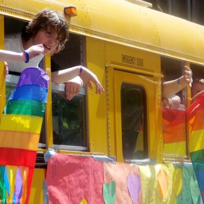 Teens on school bus with LGBT flags