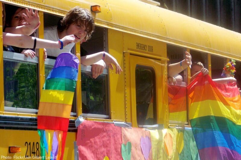 Teens on school bus with LGBT flags