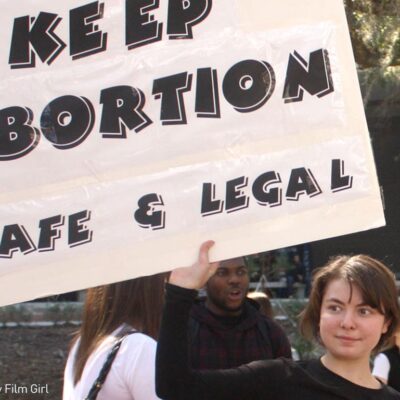 Girl holding "Keep Abortion Safe and Legal" sign