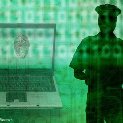 Silhouette of a police officer beside a laptop with fingerprint