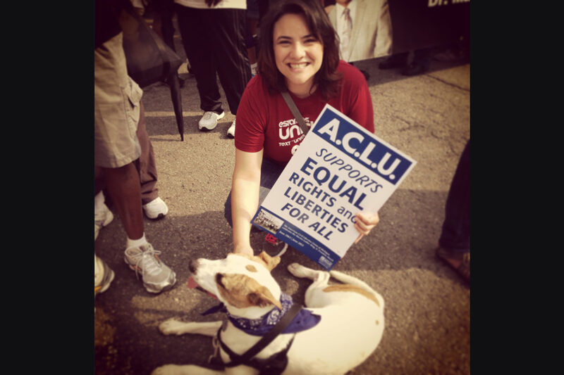 Rana Elmir and her pit bull, Olivia, at a rally with an ACLU sign