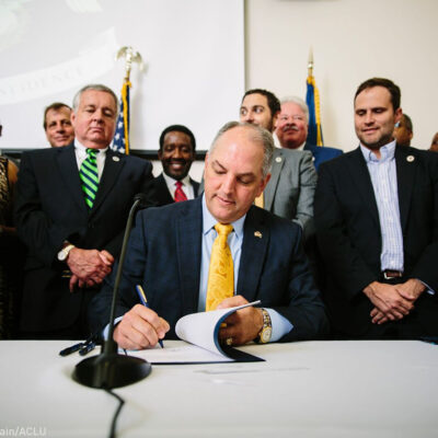 Gov. Edwards signs historic justice reinvestment legislation in a room full of advocates.