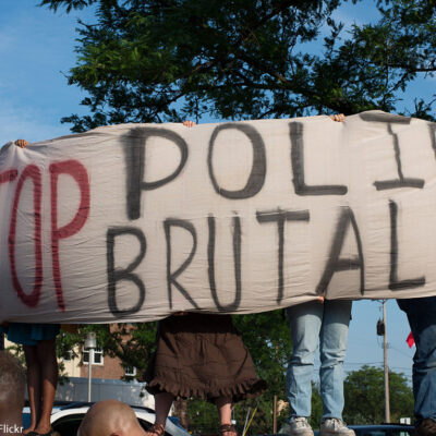 Protesters holding "Stop Police Brutality" sign