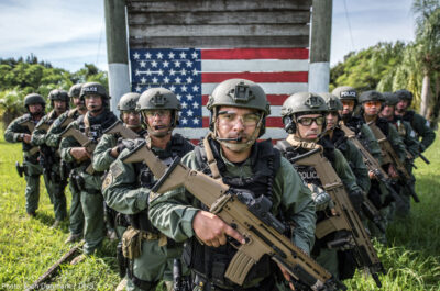 ICE Agents in V formation in front of a painter american flag