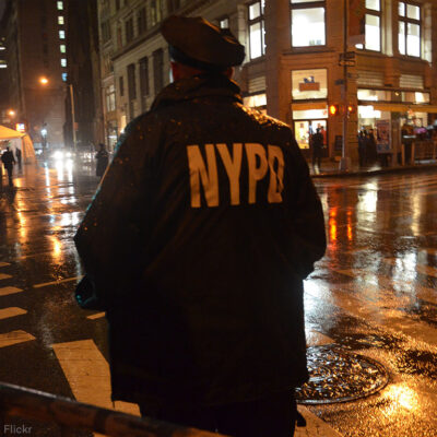 NYPD Officer standing on corner at night
