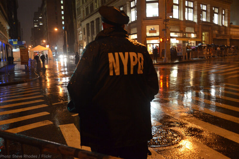 NYPD Officer standing at corner at night