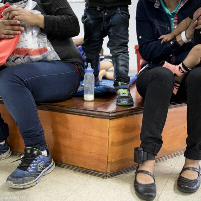 Immigrant women and children at a holding center with ankle monitors