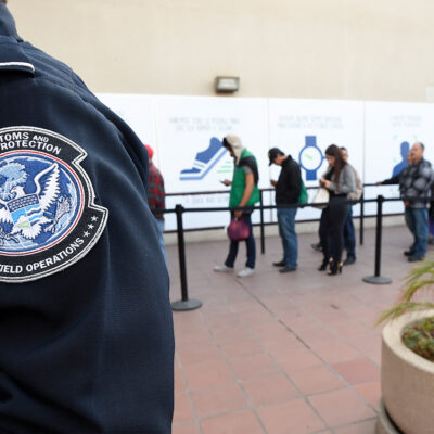 CBP Officer standing next to immigration line
