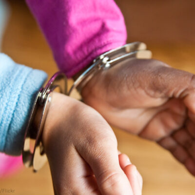 Hands of a child in handcuffs