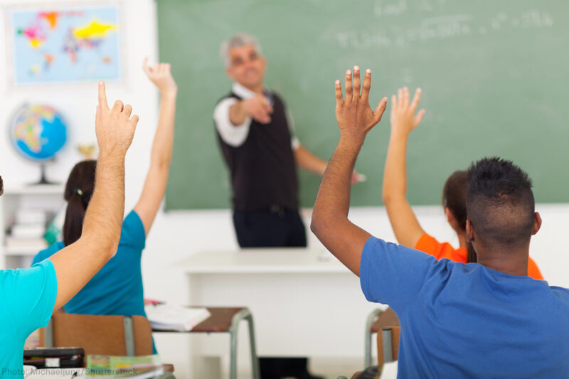 Students raising hands in class