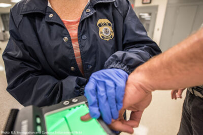 ICE agent taking fingerprints