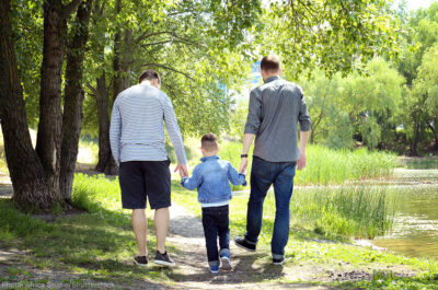 Two men walking with their child