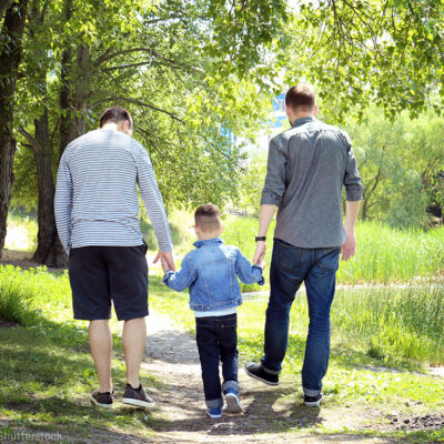 Two men walking with their child