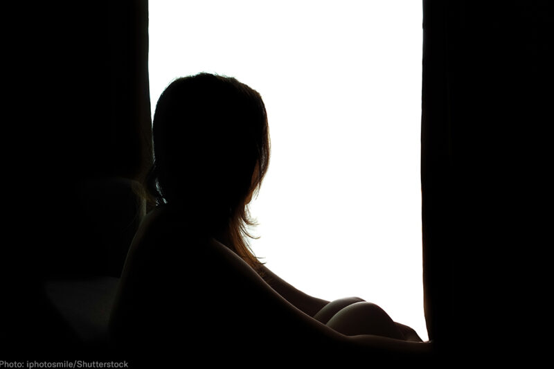 Silhouette of a woman by a window
