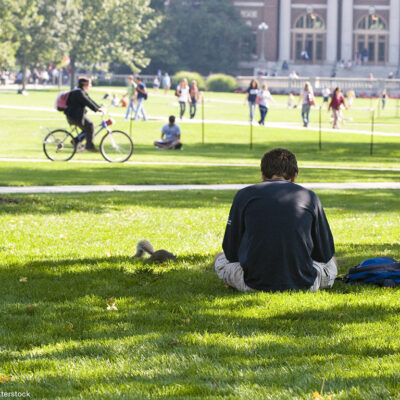 Student reading on the campus lawn
