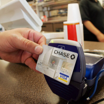 A customer uses a contactless credit card at a card reader