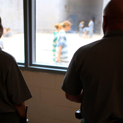 Deputies observe incarcerated people at in a women's detention area