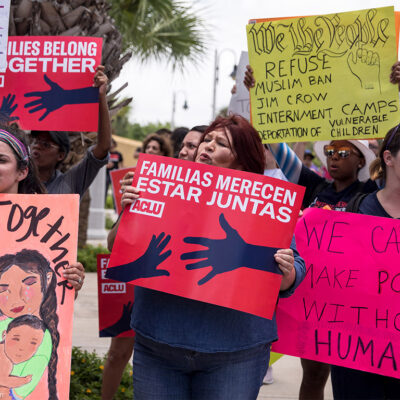 Demonstrators carrying signs urging keeping immigrant families together