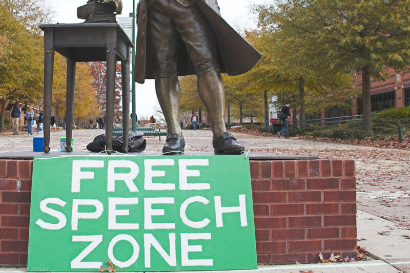 Free speech zone sign in front of statue