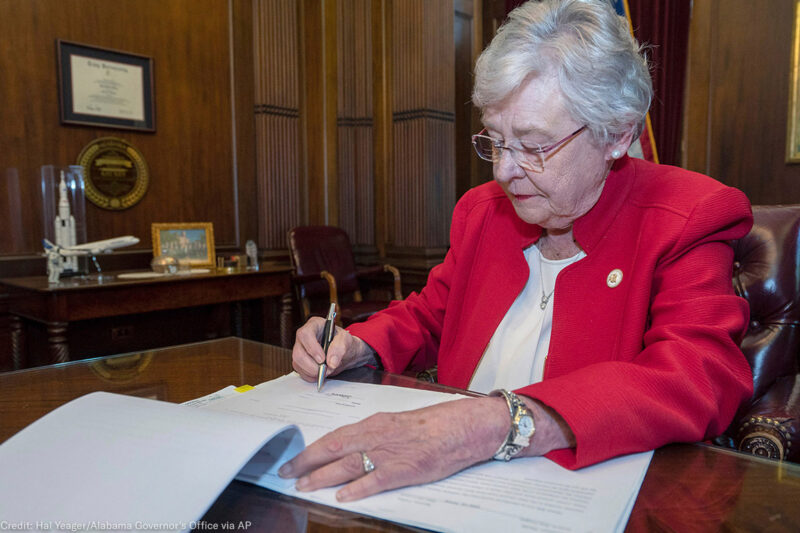 Kay Ivey signing a bill that virtually outlaws abortion in Alabama