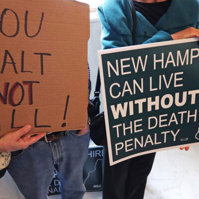 Demonstrators carrying signs advocating the abolition of the death penalty in New Hampshire