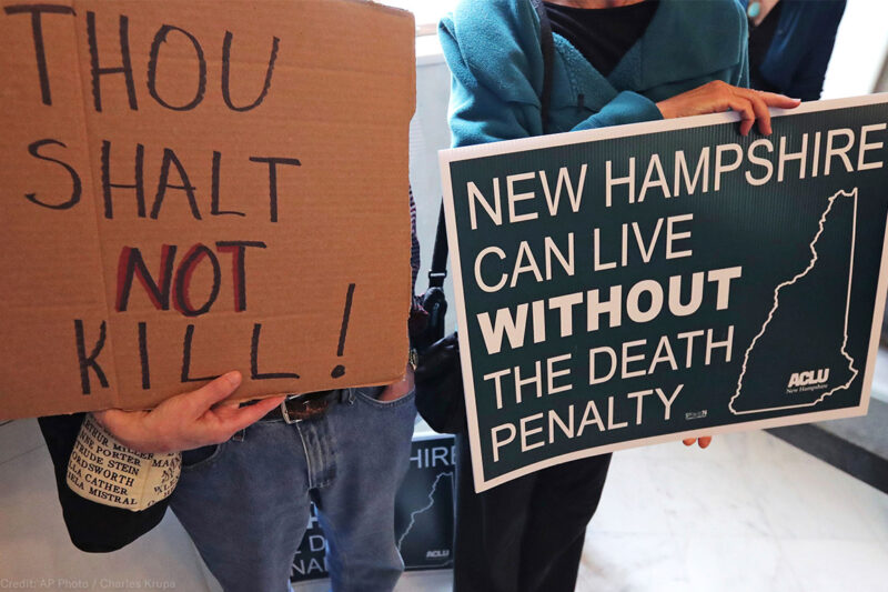 Demonstrators carrying signs advocating the abolition of the death penalty in New Hampshire