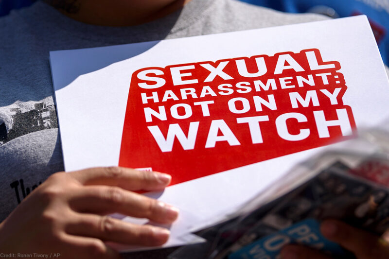 Protester holding sign stating "Sexual Harassment: Not on my Watch