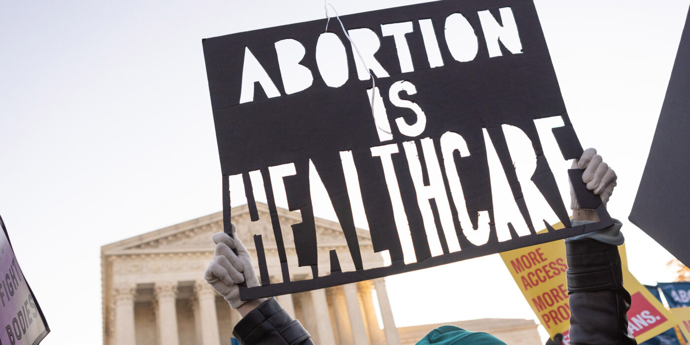 A woman holds a sign that reads "Abortion is Healthcare" in from of the Supreme Court in Washington, DC.