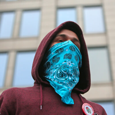 A demonstrator wearing a bandana on their face