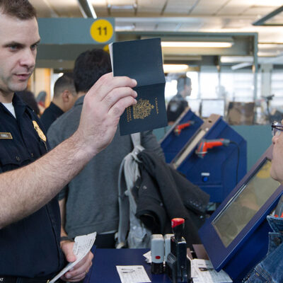 A CBP agent inspecting a passport
