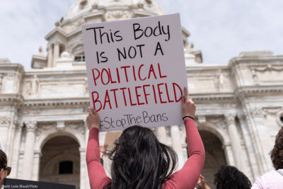 A pro-choice demonstrator with a sign with the text "This body is not a political battlefield"