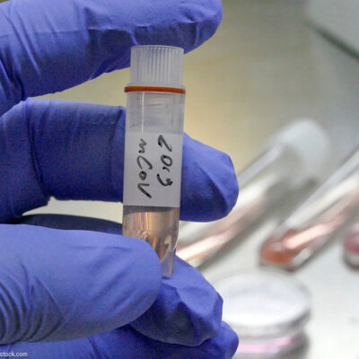 A gloved hand holding a vial of novel coronavirus 2019-nCoV in a laboratory.