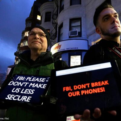 Demonstrators display iPads with the messages "FBI: Please don't make us less secure" and "FBI, don't break our phones!"