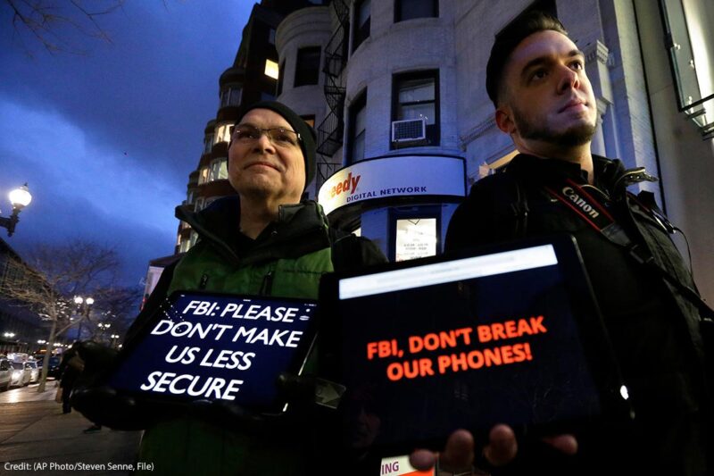Demonstrators display iPads with the messages "FBI: Please don't make us less secure" and "FBI, don't break our phones!"