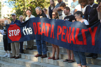 Protestors holding a banner that reads "Stop the Death Penalty" in front on Georgia's State Capital on a sunny day in 2017. Colorado just won a major feat for anti-death penalty movement with its decision to repeal the death penalty in the state.