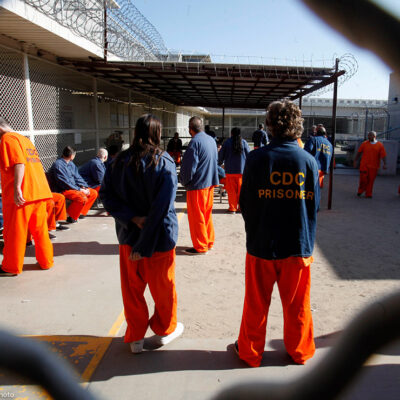 Inmates walk around a recreation yard of a California prison.