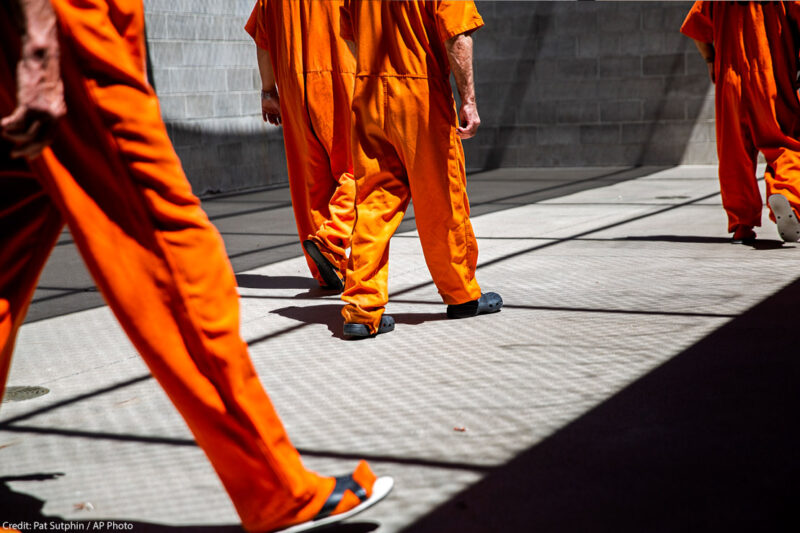inmates walk the yard during recreation time in a county jail.