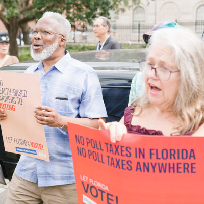 Protestors holding signs that read "no poll taxes in Florida"