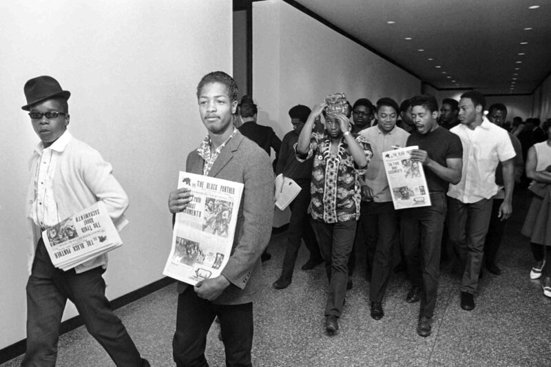Several members of the Black Panther party carry copies of the Black Panther newspaper