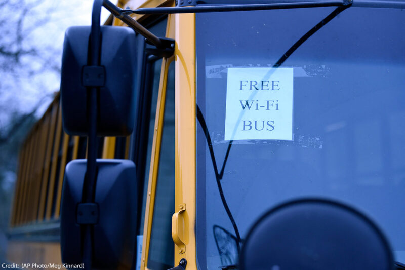 A sign on a school bus displays "FREE WIFI BUS"